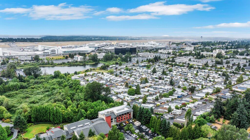 Aerial view of a suburban area with dense housing, greenery, and a nearby airport in Seatac, WA